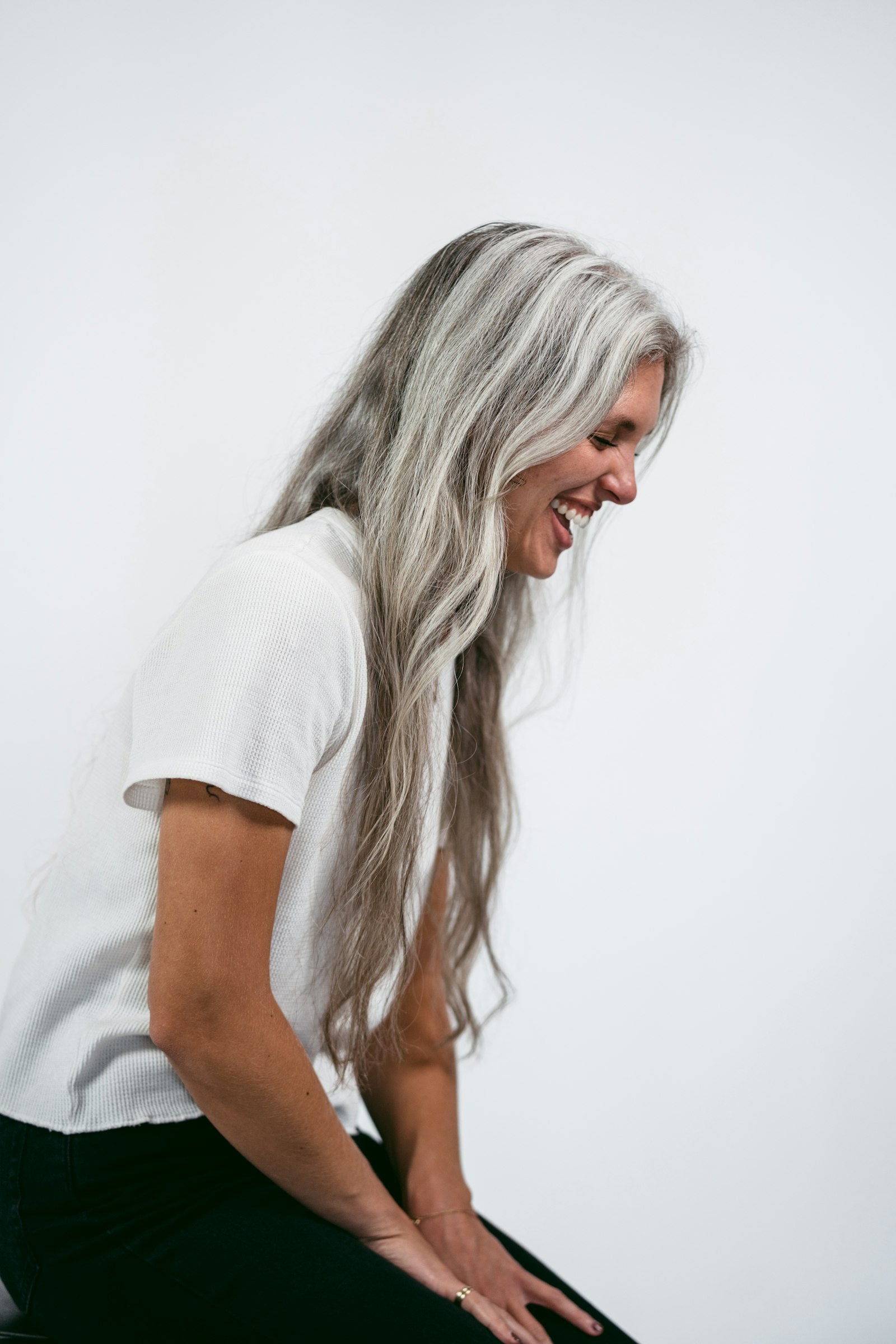 Woman with long natural silver hair, laughing
